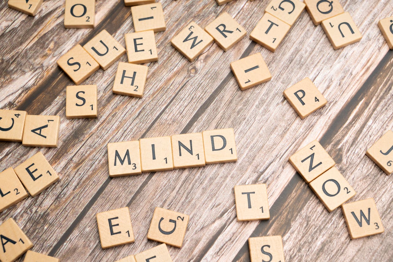hero-img-02 Scattered wooden letter tiles on a rustic wood surface highlighting the word 'Mind'. Ideal for mental and cognitive themes.