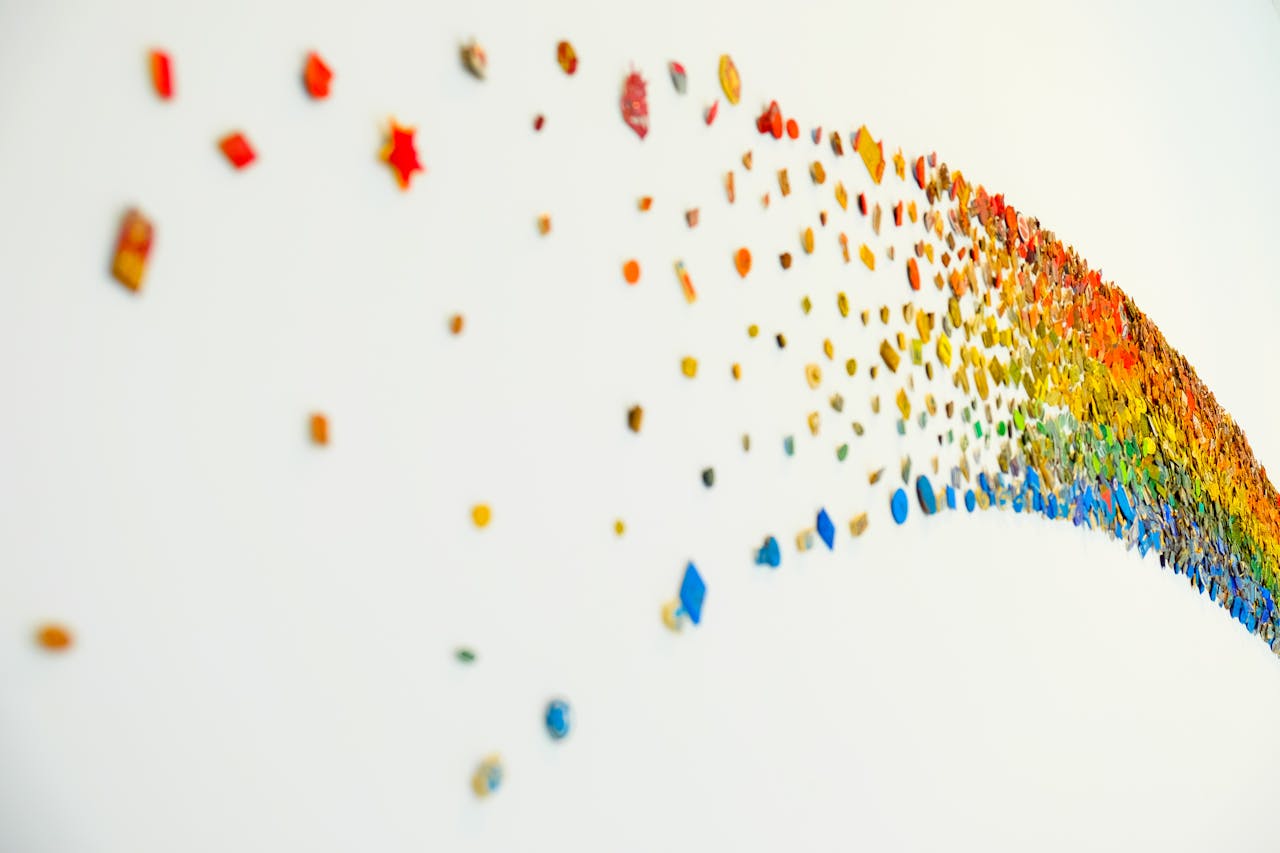 hero-img-01 Vibrant abstract rainbow art with colorful shapes on a white wall, perfect for creative backgrounds.